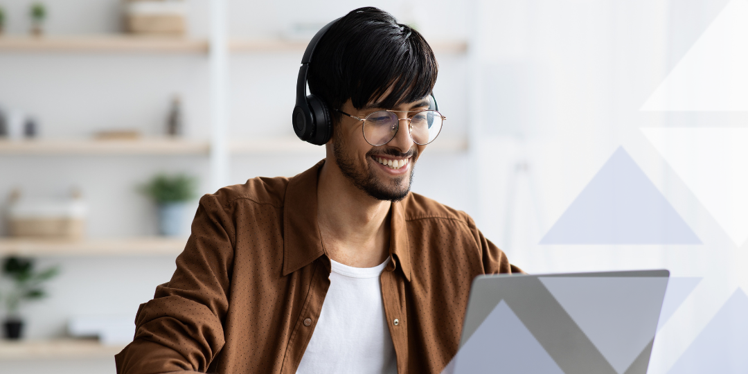 Man wearing headphones, watching webinar on laptop